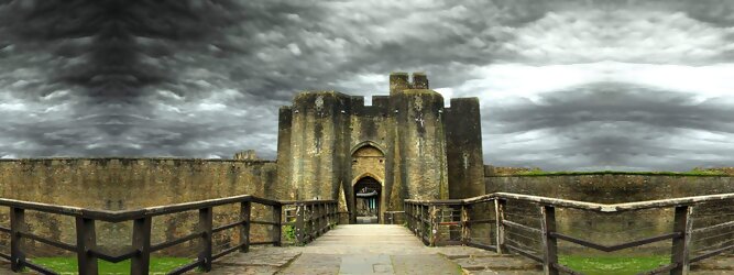 Trip Club Reisen Reisetipps - Caerphilly Castle - ein Bollwerk aus dem 13. Jahrhundert in Wales, Vereinigtes Königreich. Mit einem aufsehenerregenden Turm, der schiefer ist wie der Schiefe Turm zu Pisa. Wie jede Burg mit Prestige, hat sie auch einen Geist, „The Green Lady“ spukt in den Gemächern, wo ihr Geliebter den Tod fand. Wo man in Wales oft – und nicht ohne Grund – das Gefühl hat, dass ein Schloss ziemlich gleich ist, ist Caerphilly Castle bei Cardiff eine sehr willkommene Abwechslung. Die Burg ist nicht nur deutlich größer, sondern auch älter als die Burgen, die später von Edward I. als Ring um Snowdonia gebaut wurden.